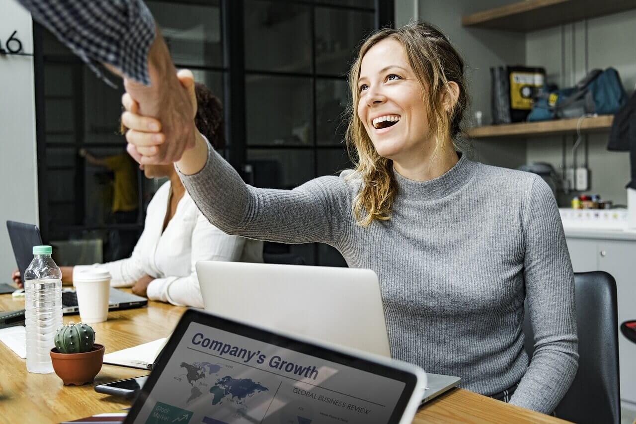 Smiling Women shaking hands with client